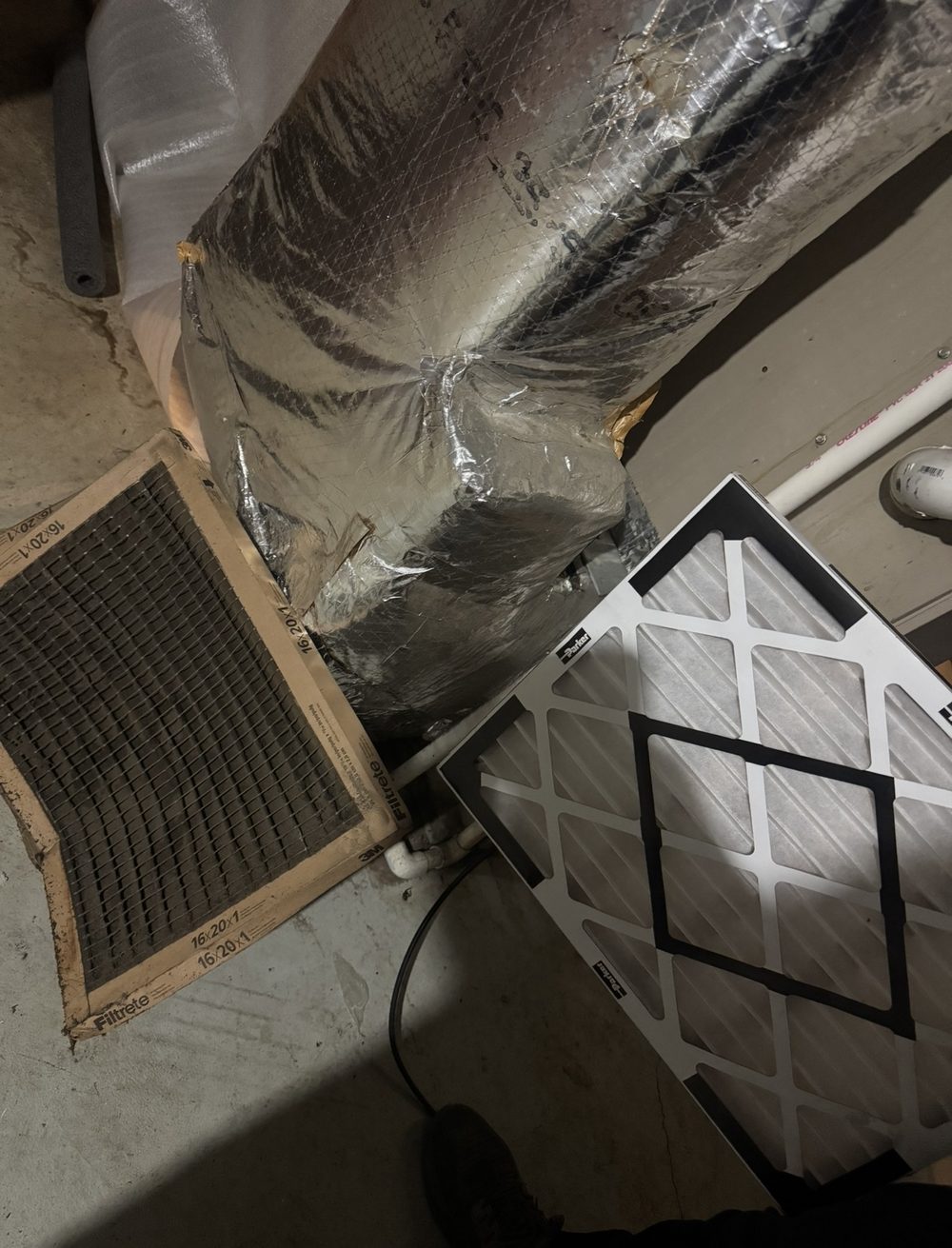 Before and after air filter comparison — a black clogged 16x20 filter next to a clean new pleated filter