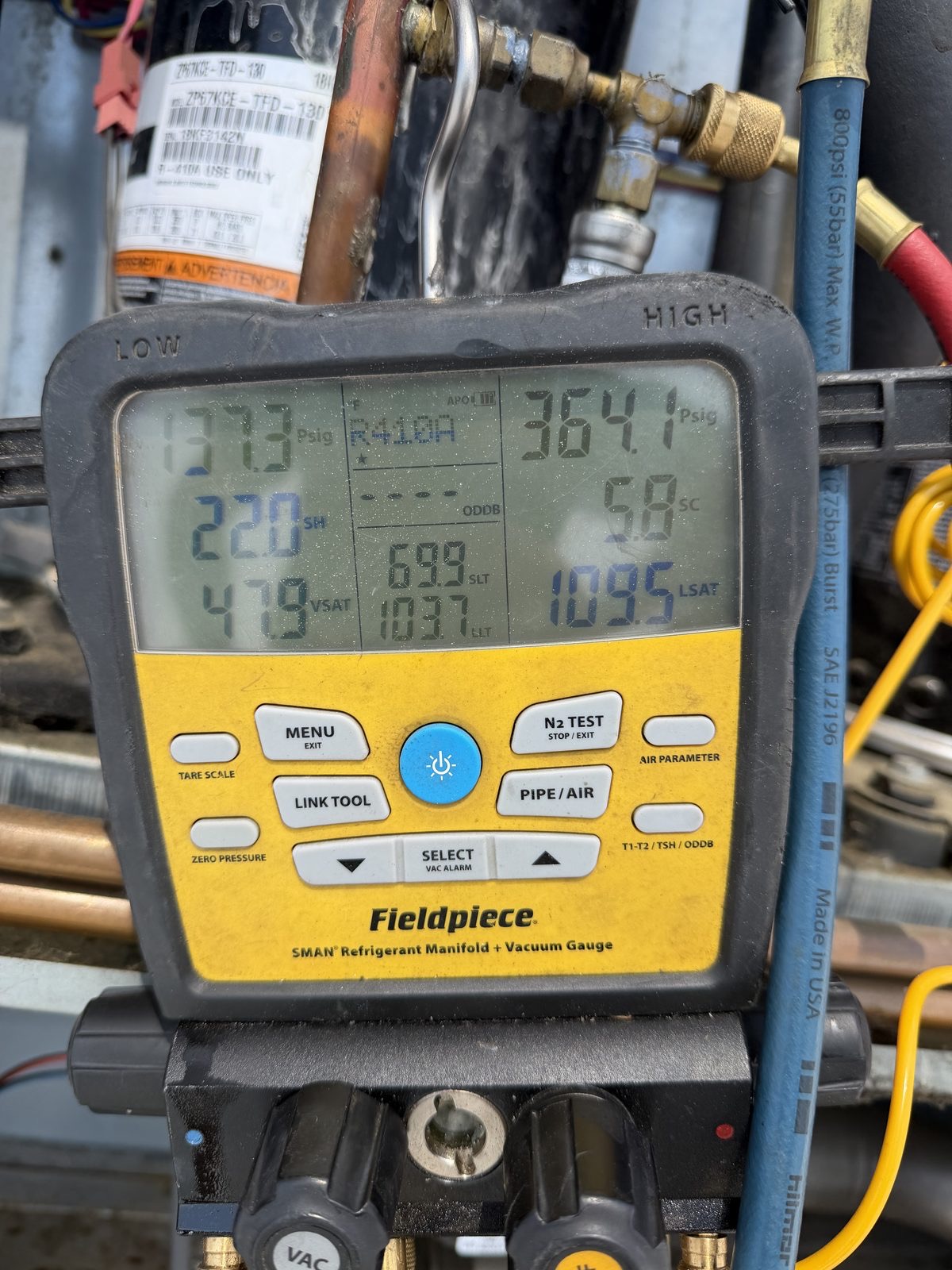 Lumen technician's refrigerant gauges during an AC repair diagnostic in the Philadelphia area