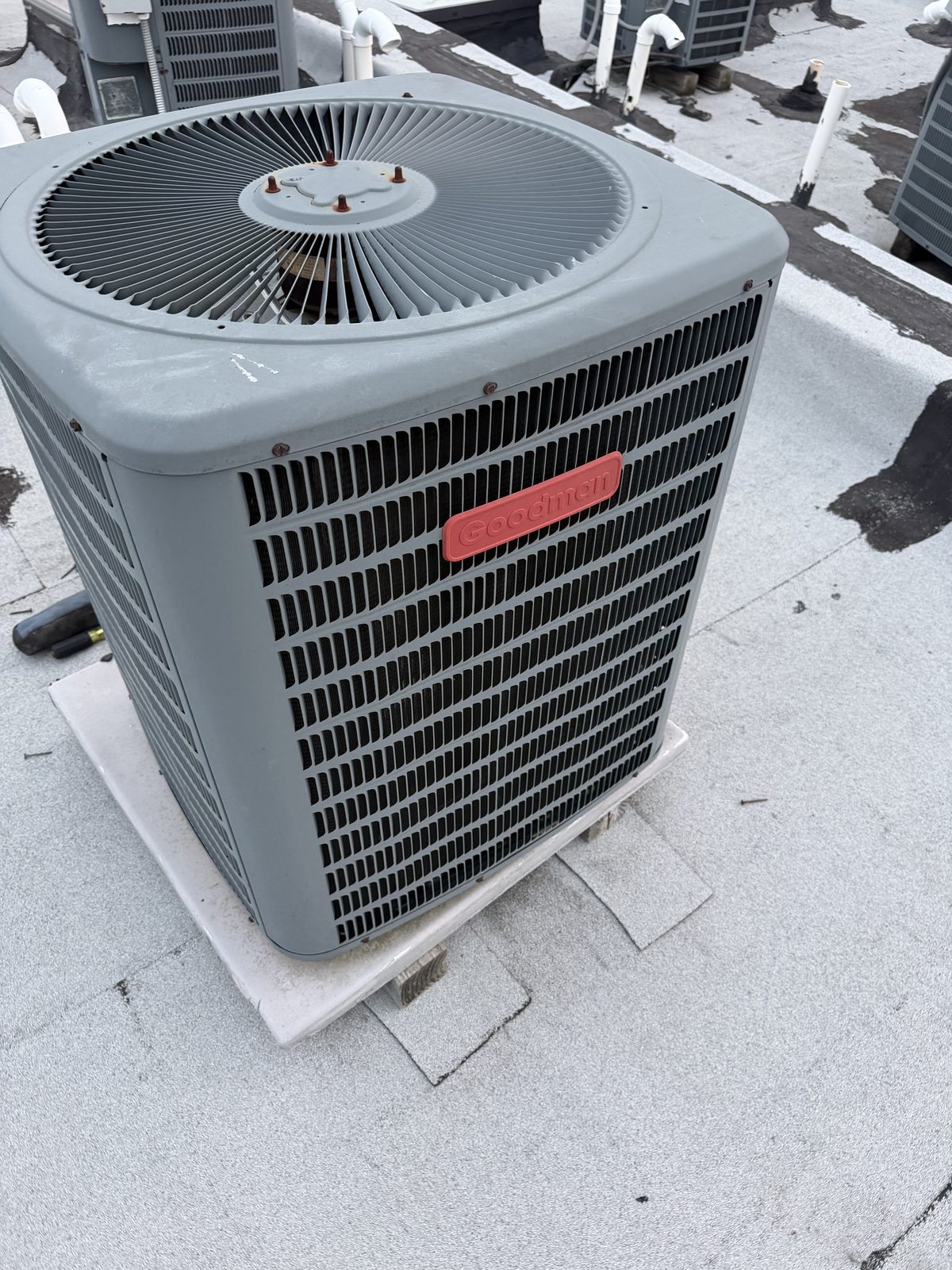 New Goodman condenser set on a rooftop stand by Lumen Heating and Cooling