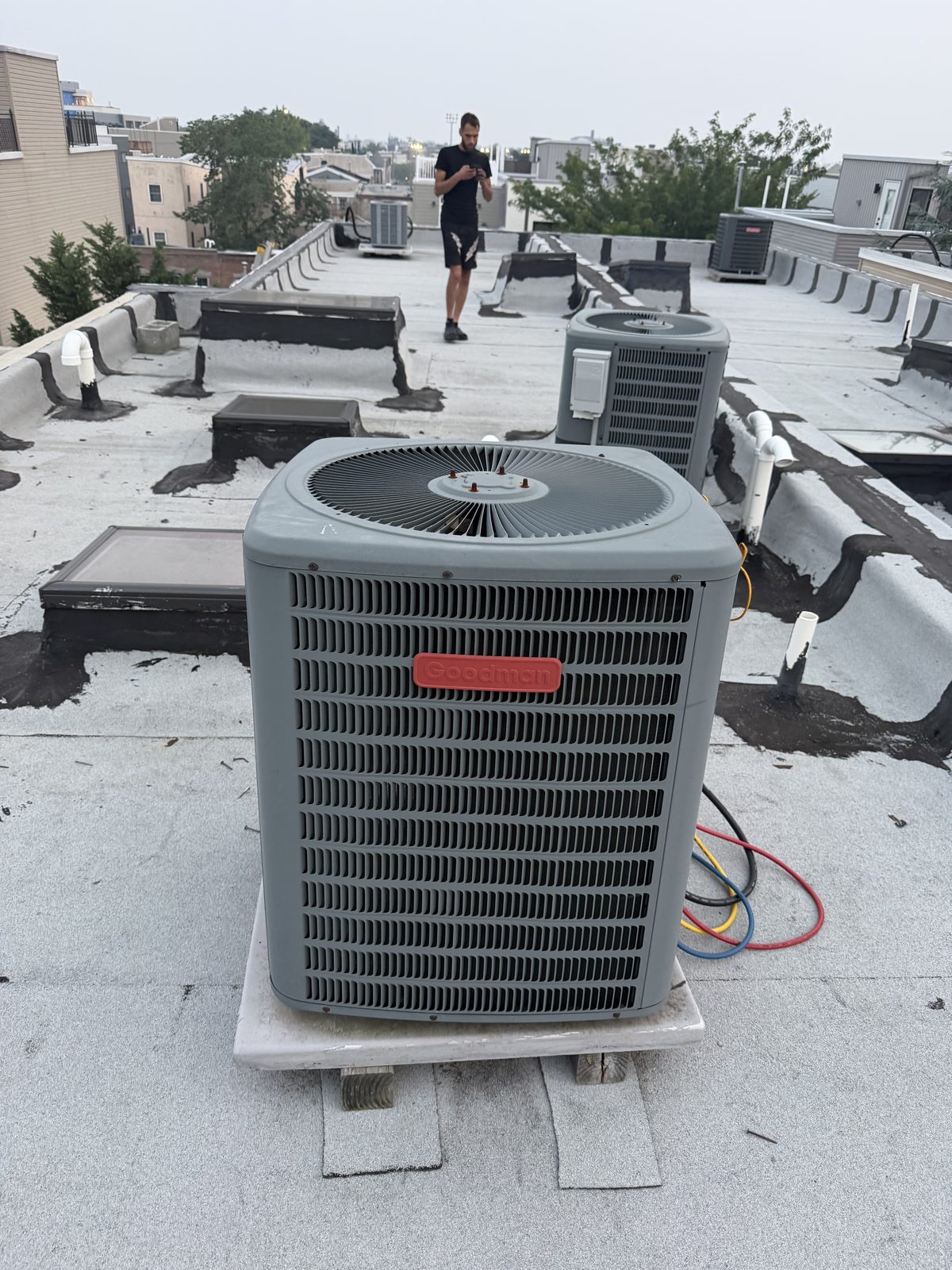 Multiple new Goodman condensers installed across a flat commercial rooftop by Lumen Heating and Cooling
