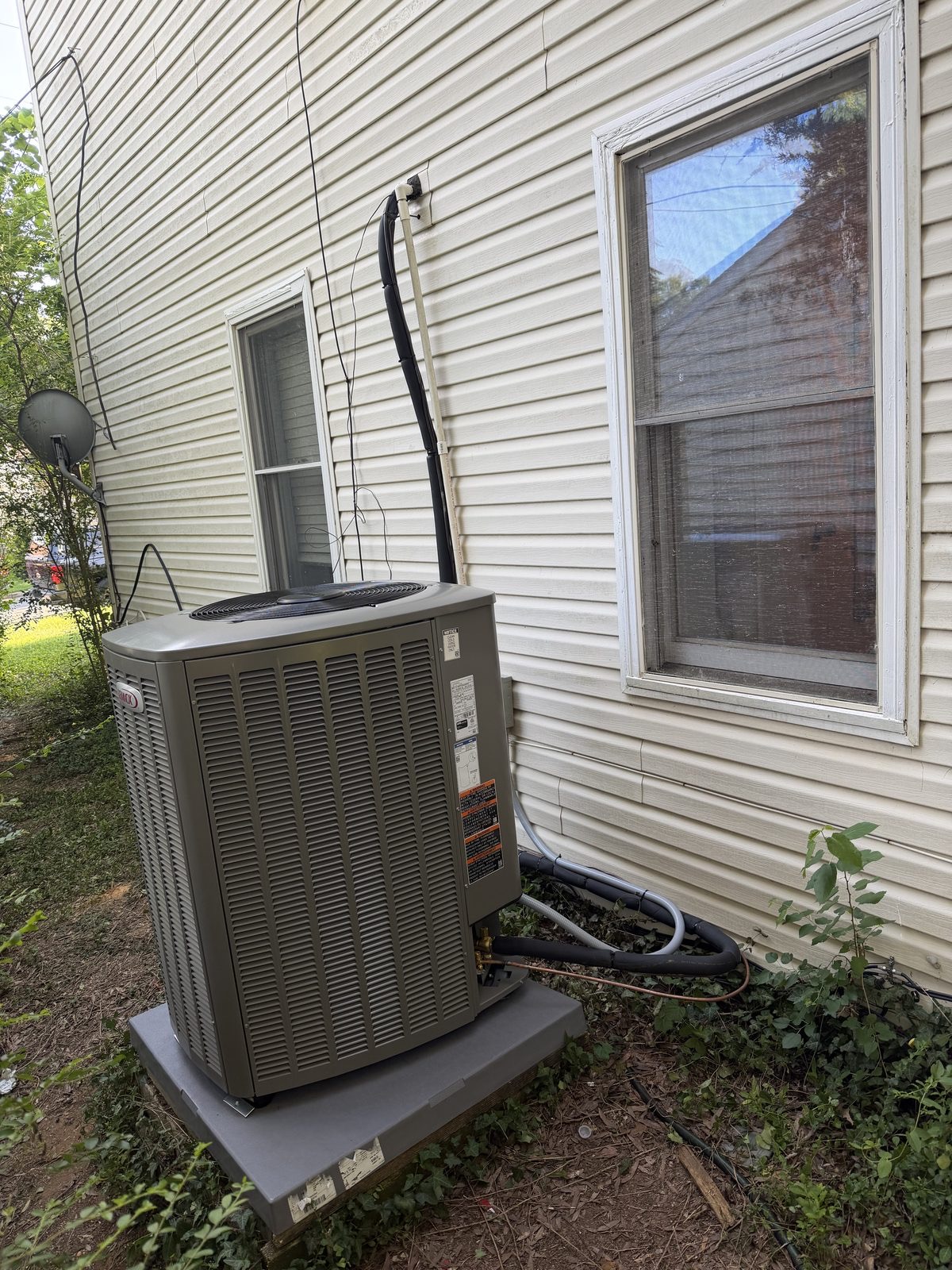 Lennox heat pump outdoor unit mounted on a wall bracket by Lumen Heating and Cooling