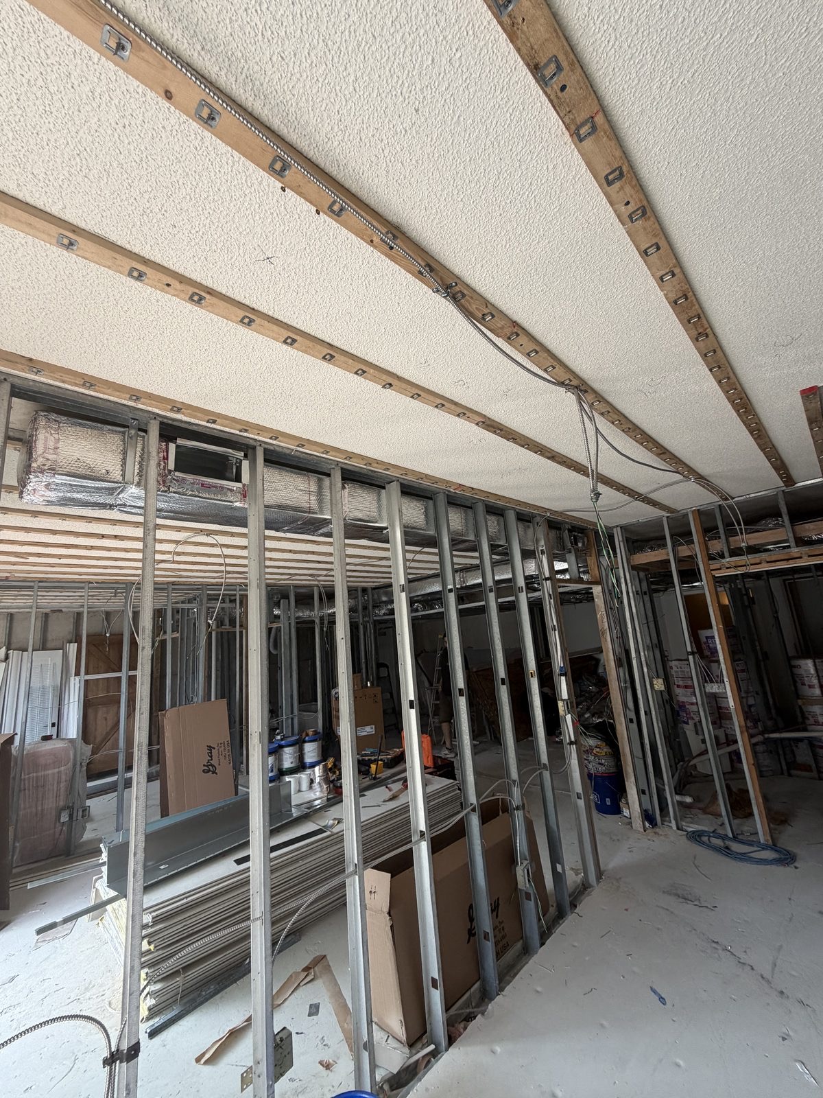 HVAC ductwork rough-in through metal stud framing at a new construction project