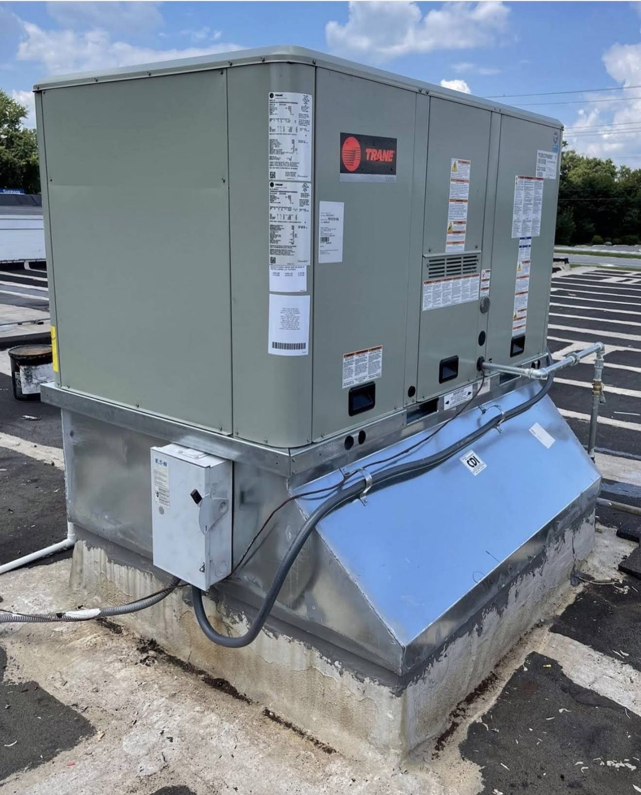 Side view of the Trane commercial rooftop packaged unit on its curb adapter